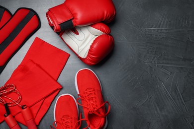 Photo of Sportswear, sneakers, boxing gloves, skipping rope and ankle weights on grey background, flat lay. Space for text