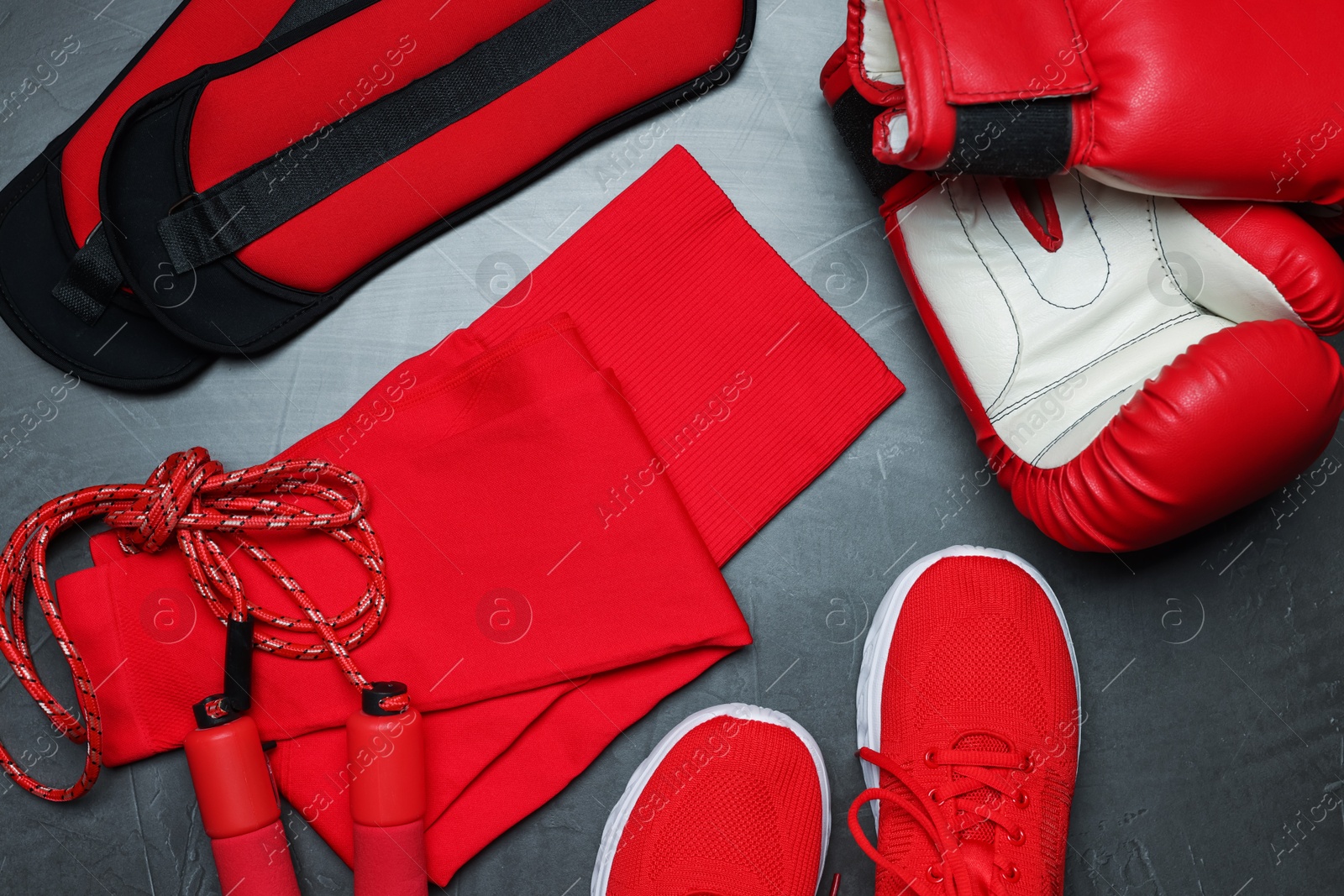 Sportswear, sneakers, boxing gloves, skipping rope and ankle weights on grey background, flat lay Photo of Sportswear, sneakers, boxing gloves, skipping rope and ankle weights on grey background, flat lay
