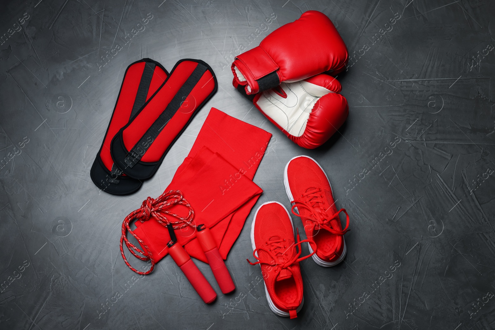 Sportswear, sneakers, boxing gloves, skipping rope and ankle weights on grey background, flat lay Photo of Sportswear, sneakers, boxing gloves, skipping rope and ankle weights on grey background, flat lay