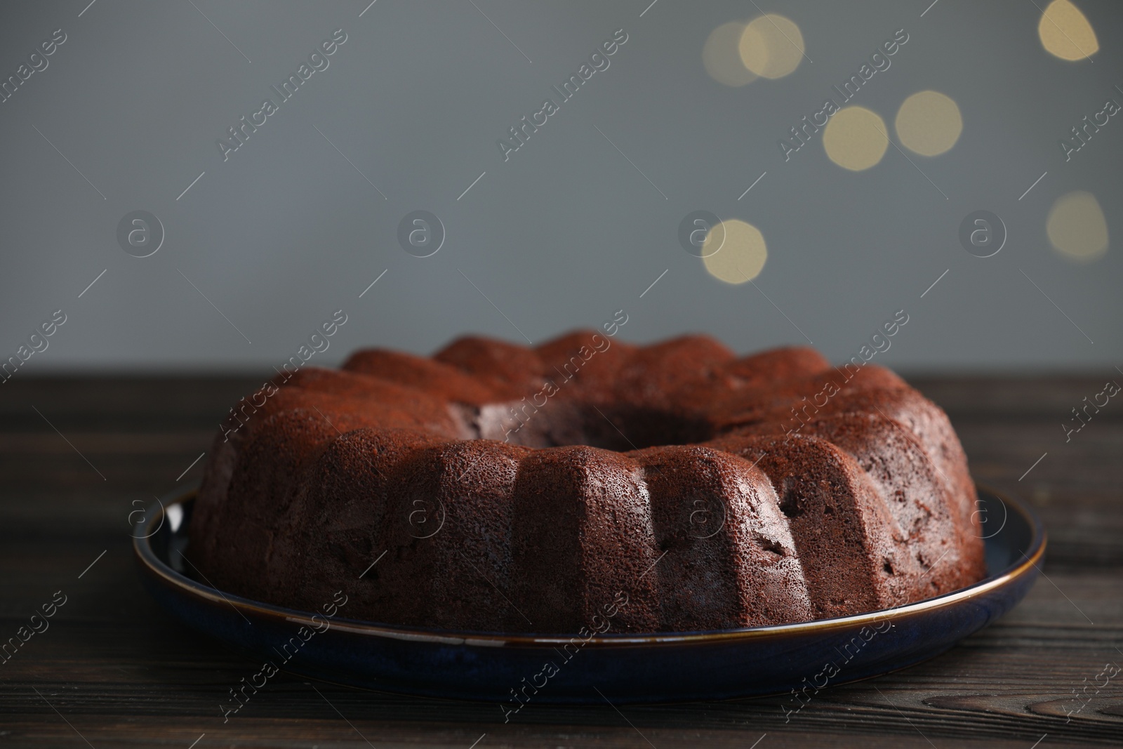Tasty chocolate bundt cake on wooden table, closeup. Bokeh effect Photo of Tasty chocolate bundt cake on wooden table, closeup. Bokeh effect