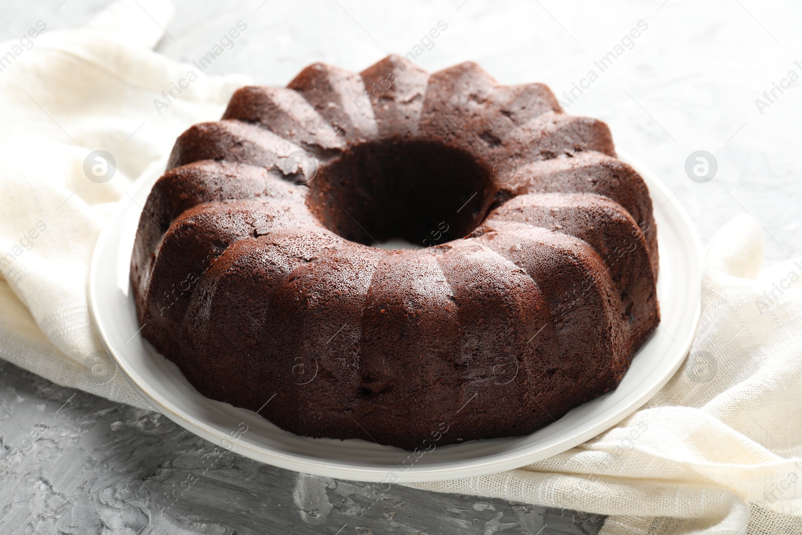 Tasty chocolate bundt cake on grey table, closeup Photo of Tasty chocolate bundt cake on grey table, closeup