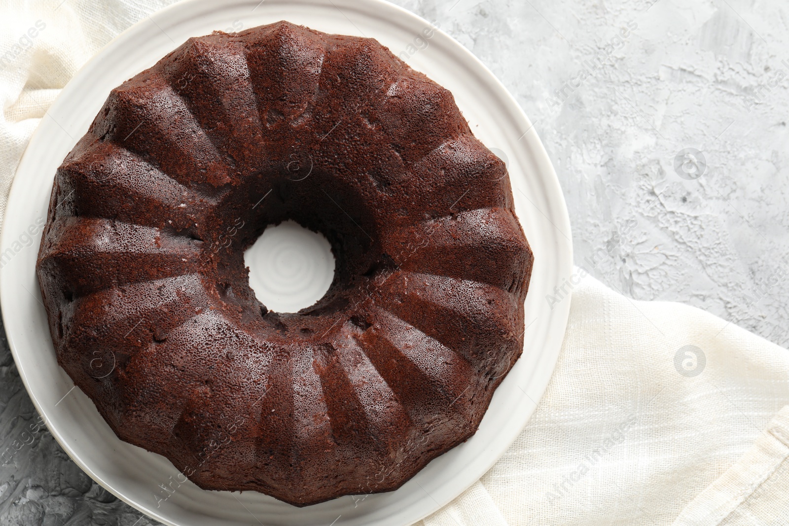 Tasty chocolate bundt cake on grey table, top view. Space for text Photo of Tasty chocolate bundt cake on grey table, top view. Space for text