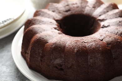 Photo of Tasty chocolate bundt cake on grey table, closeup