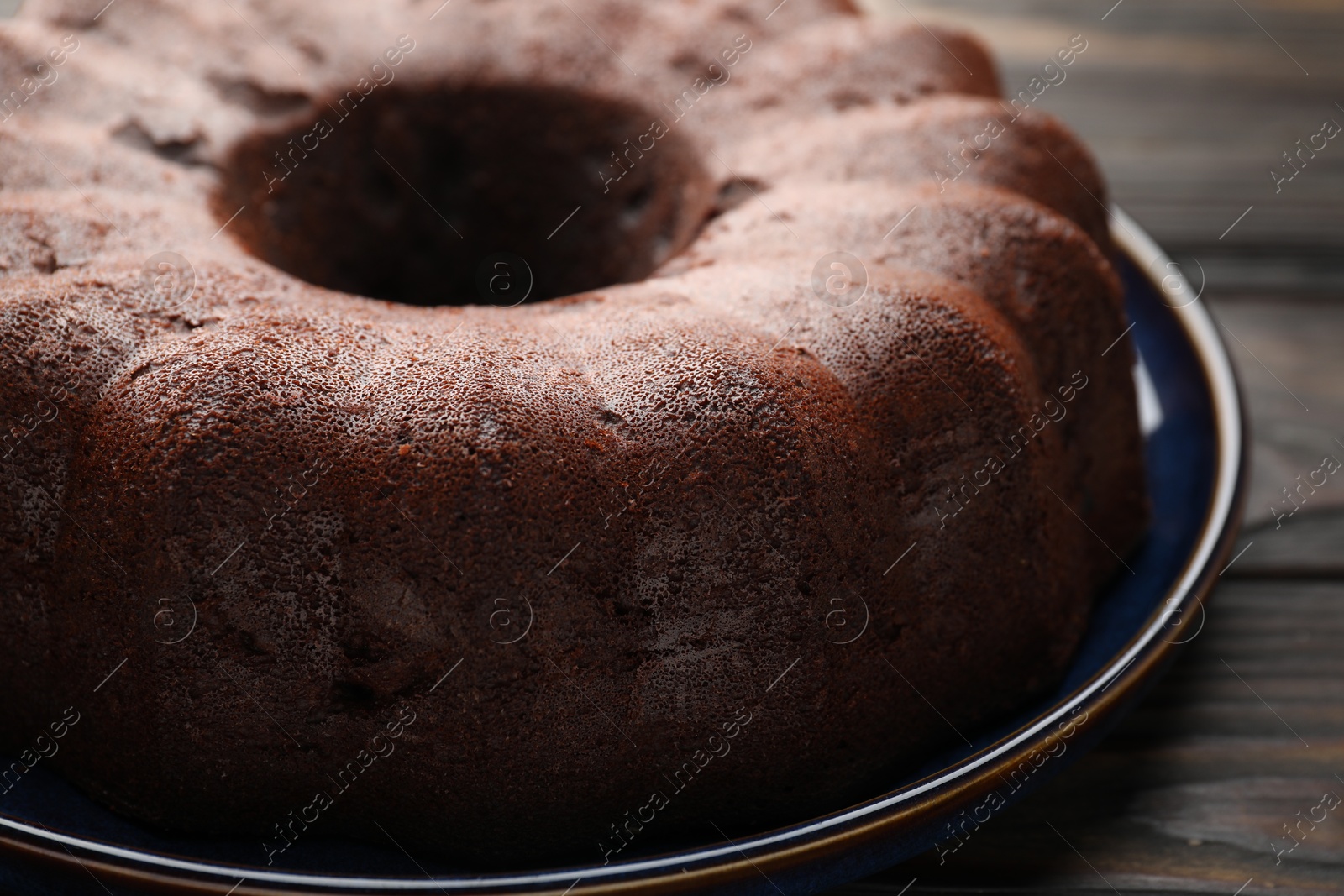 Tasty chocolate bundt cake on wooden table, closeup Photo of Tasty chocolate bundt cake on wooden table, closeup