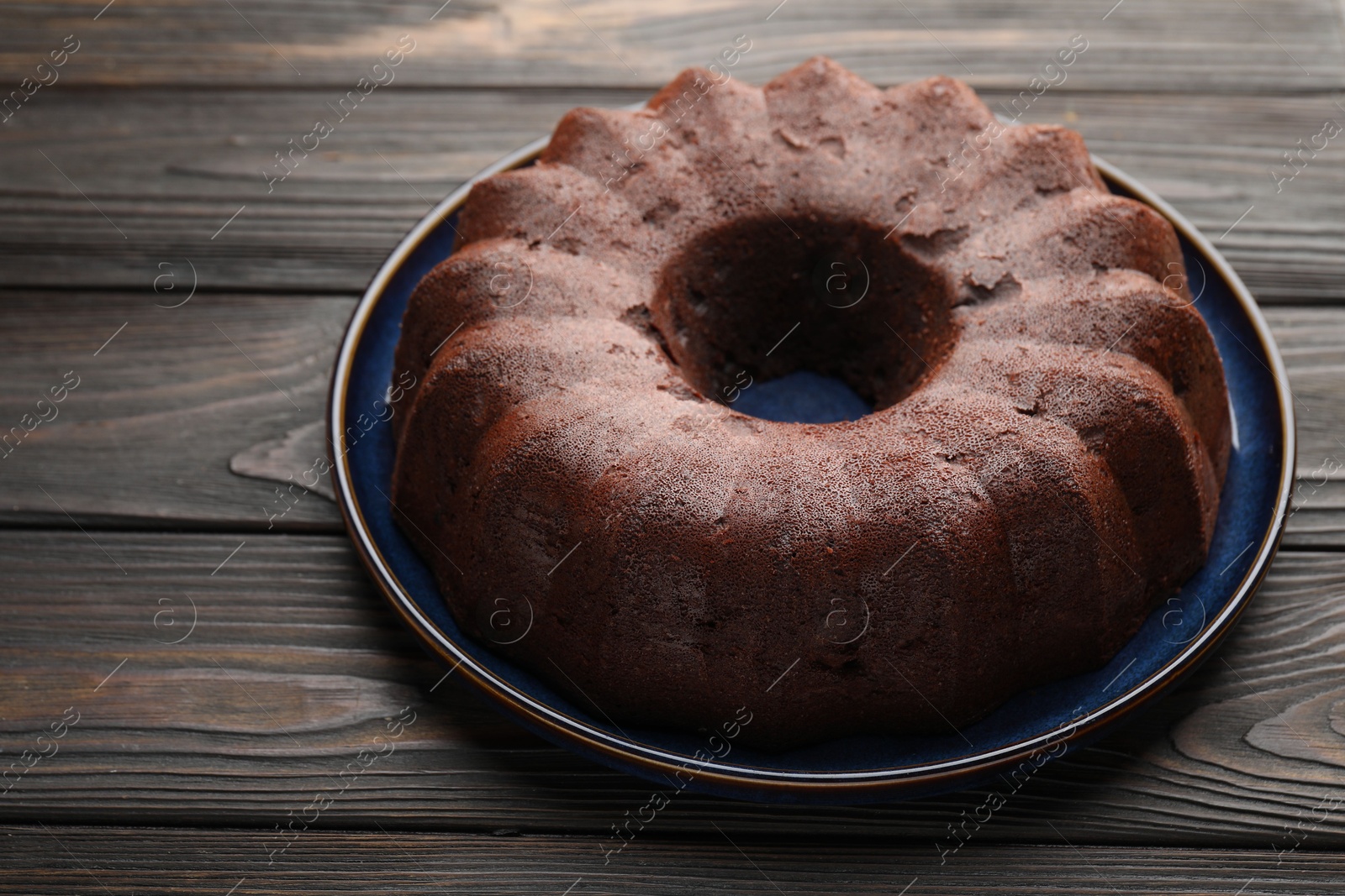 Tasty chocolate bundt cake on wooden table, closeup Photo of Tasty chocolate bundt cake on wooden table, closeup