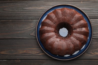 Photo of Tasty chocolate bundt cake on wooden table, top view. Space for text