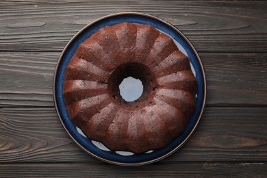 Photo of Tasty chocolate bundt cake on wooden table, top view