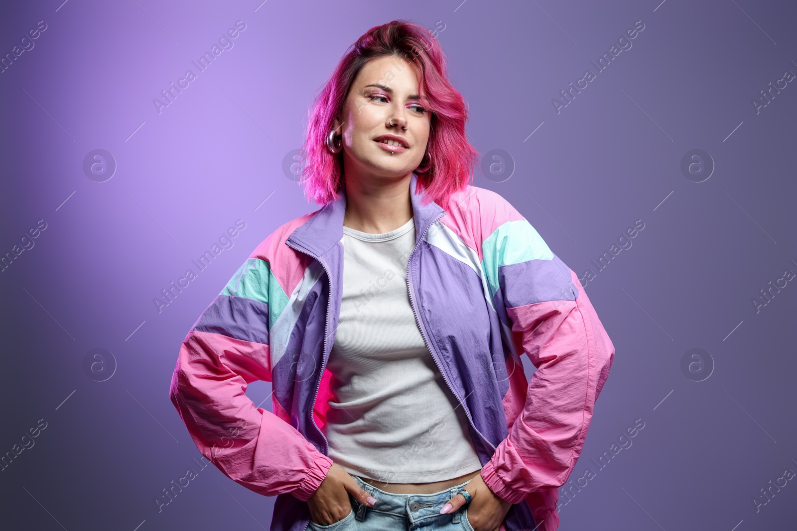 Beautiful woman with pink dyed hair on violet gradient background Photo of Beautiful woman with pink dyed hair on violet gradient background
