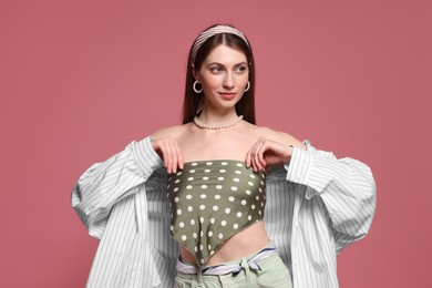 Photo of Fashionable portrait of beautiful woman in stylish outfit on pink background