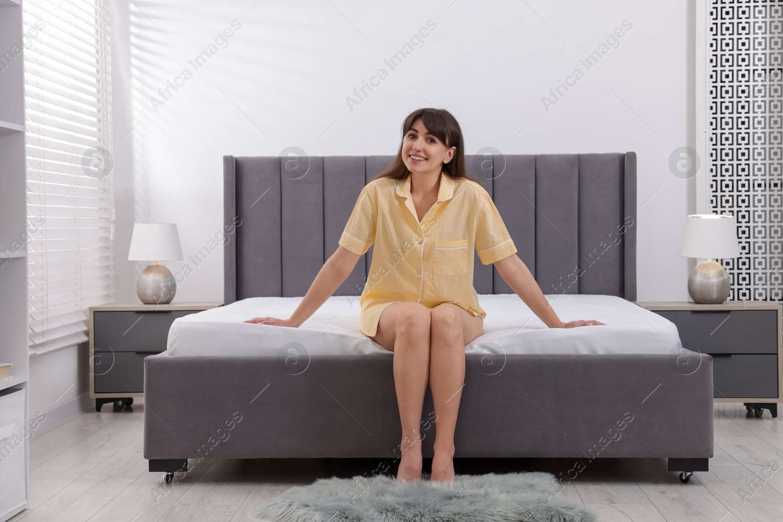 Photo of Beautiful woman sitting on soft mattress at home