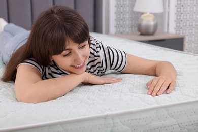 Photo of Beautiful woman lying on soft mattress at home