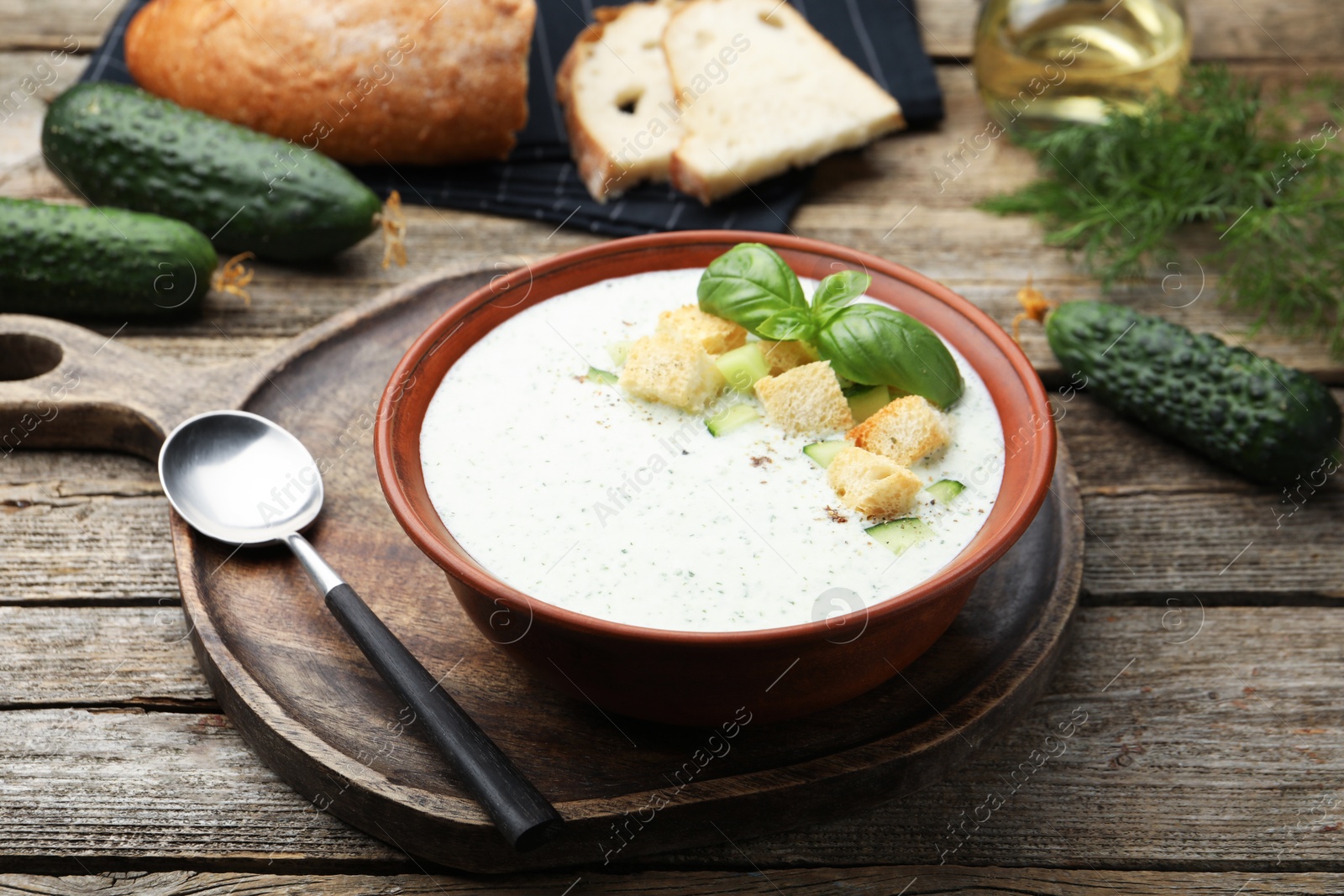 Tasty cucumber soup with croutons and basil served on wooden table, closeup Photo of Tasty cucumber soup with croutons and basil served on wooden table, closeup