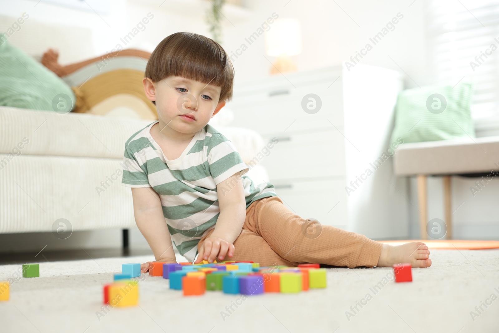 Cute little child playing with colorful cubes at home. Space for text Photo of Cute little child playing with colorful cubes at home. Space for text