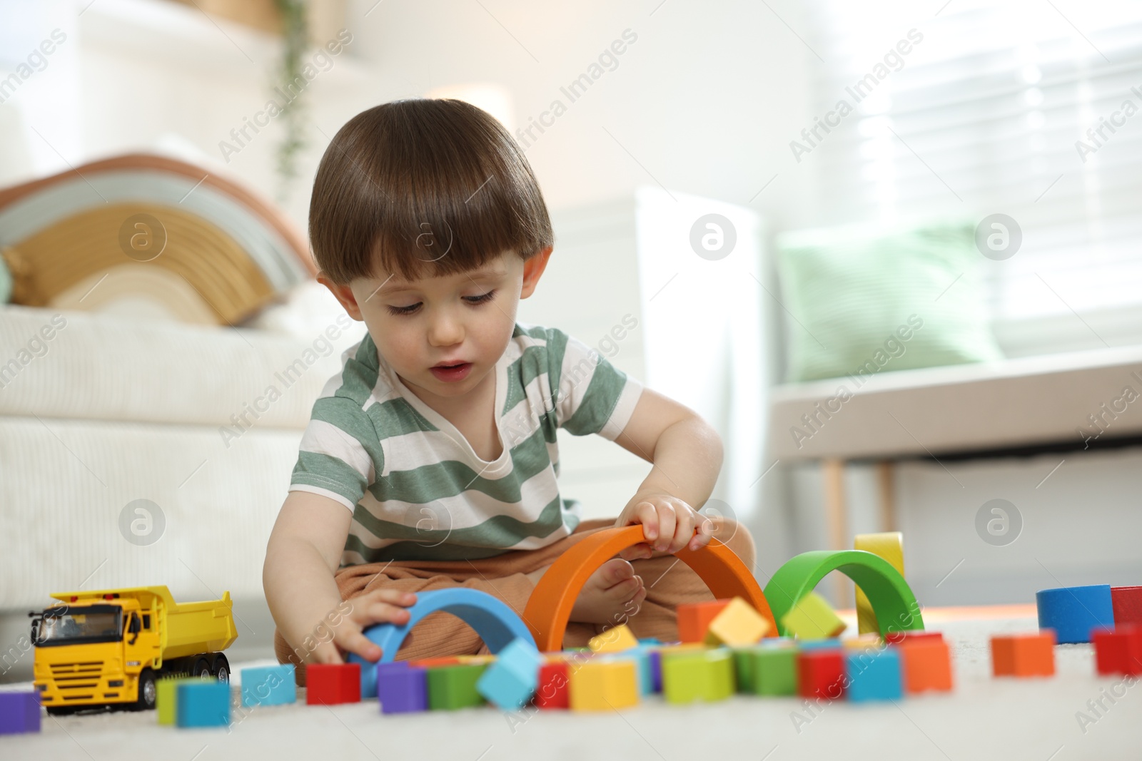 Cute little child playing with colorful cubes at home. Space for text Photo of Cute little child playing with colorful cubes at home. Space for text