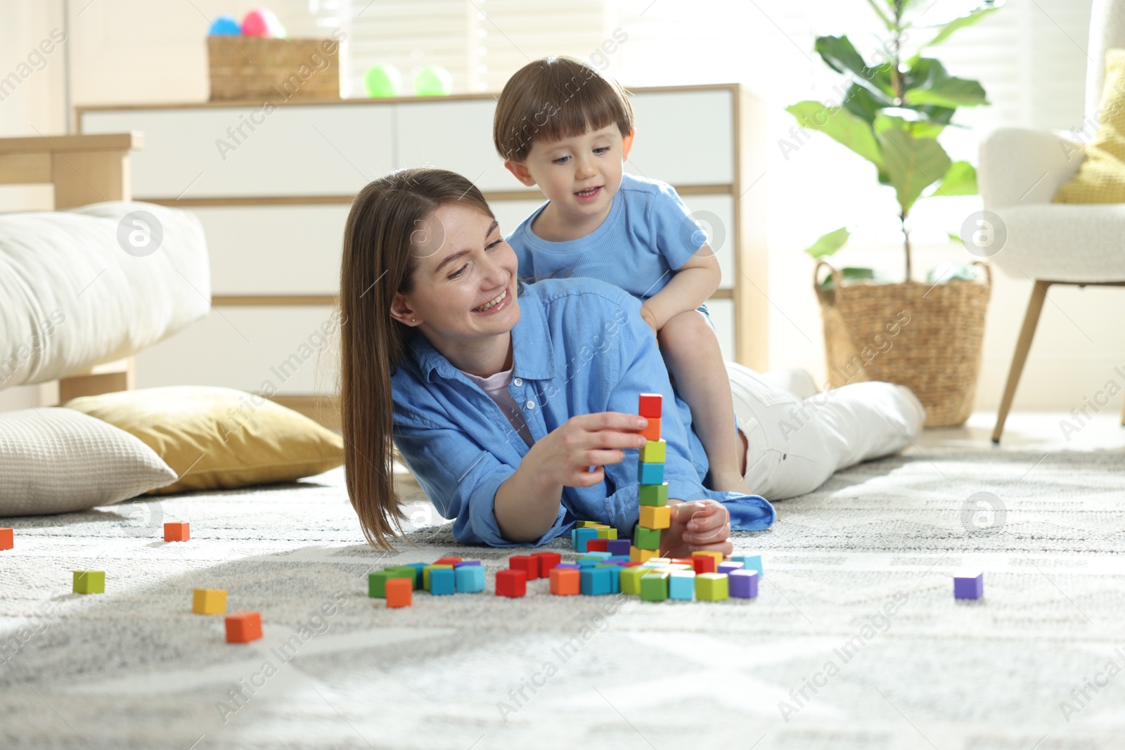 Mother and son playing with colorful cubes at home Photo of Mother and son playing with colorful cubes at home