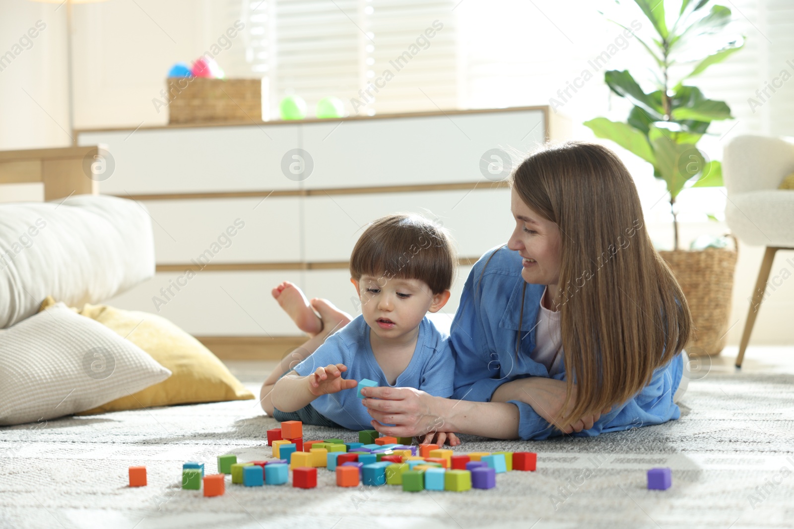 Mother and son playing with colorful cubes at home. Space for text Photo of Mother and son playing with colorful cubes at home. Space for text