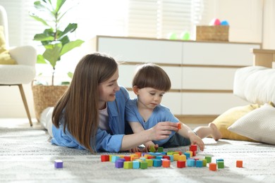 Photo of Mother and son playing with colorful cubes at home