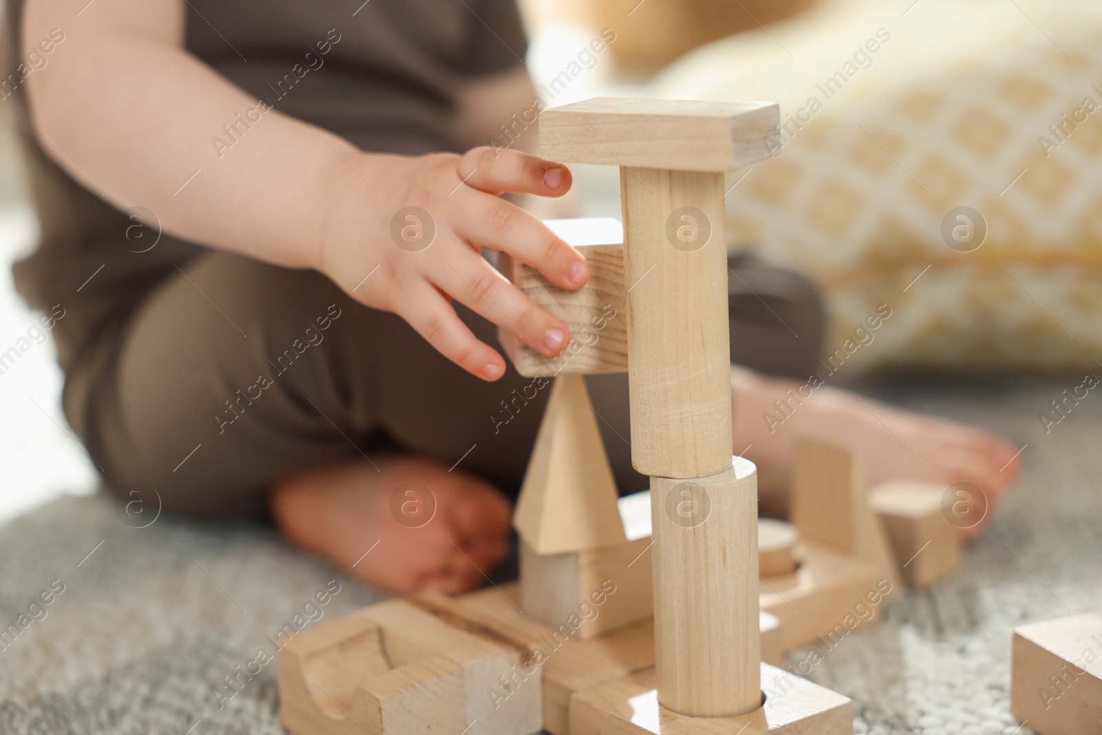 Cute little child playing with wooden building blocks at home, closeup Photo of Cute little child playing with wooden building blocks at home, closeup