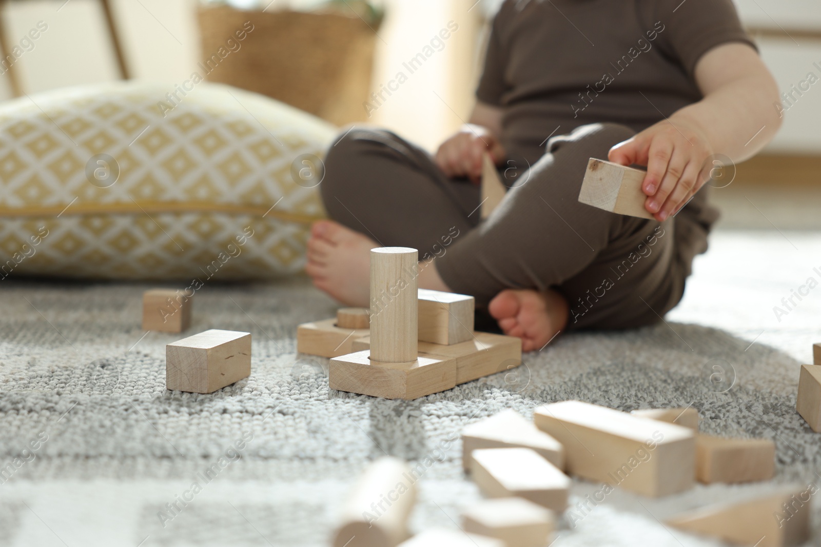 Cute little child playing with wooden building blocks at home, closeup. Space for text Photo of Cute little child playing with wooden building blocks at home, closeup. Space for text