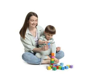 Photo of Mother and son playing with colorful cubes on white background