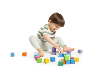 Photo of Cute little child playing with colorful cubes on white background