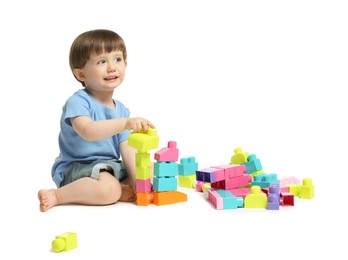 Photo of Cute little boy playing with building bricks on white background
