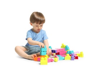 Photo of Cute little boy playing with building bricks on white background