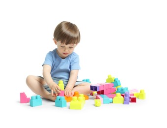 Photo of Cute little boy playing with building bricks on white background