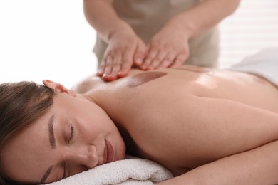 Photo of Cupping therapy. Woman receiving professional massage in spa salon, closeup