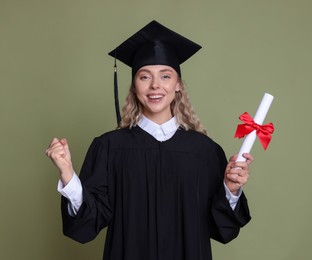 Photo of Happy student with diploma after graduation on green background