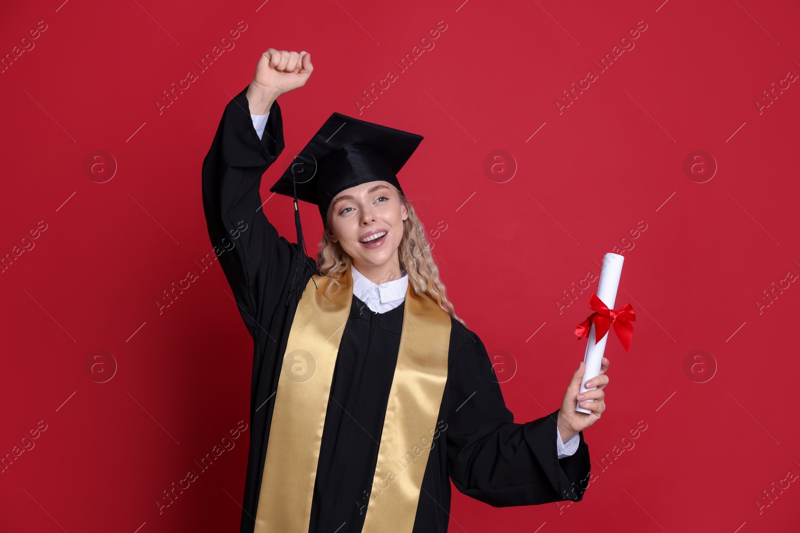 Photo of Happy student with diploma after graduation on red background