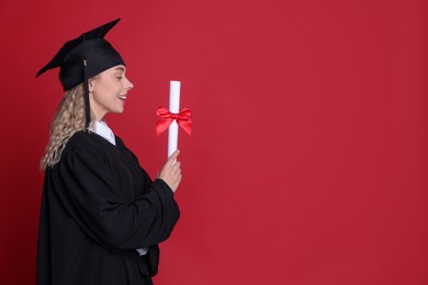 Photo of Happy student with diploma after graduation on red background. Space for text