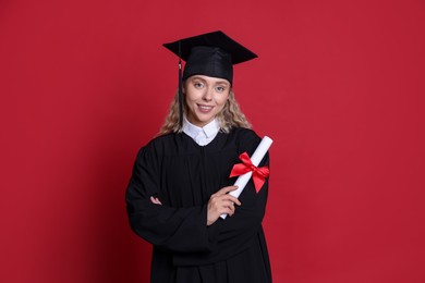 Photo of Happy student with diploma after graduation on red background
