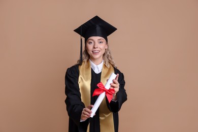 Photo of Happy student with diploma after graduation on beige background