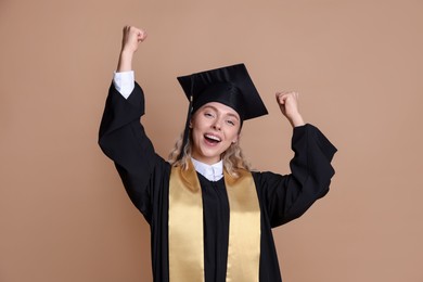 Photo of Happy student after graduation on beige background