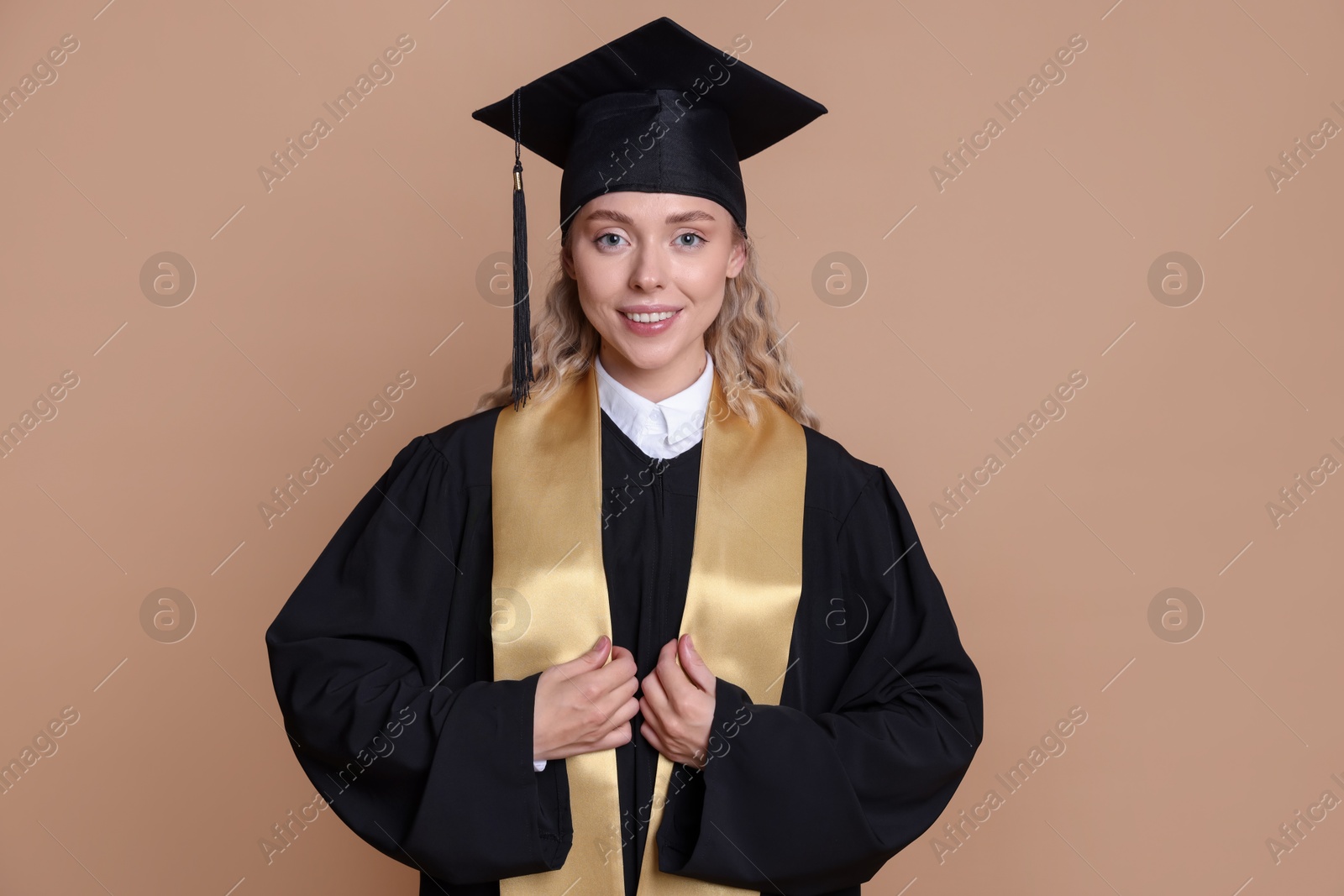 Happy student after graduation on beige background Photo of Happy student after graduation on beige background