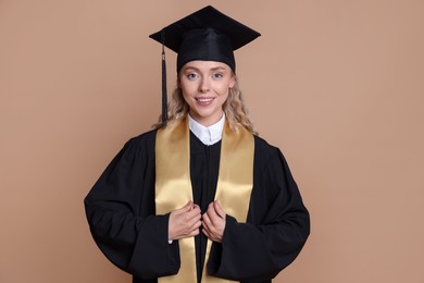 Photo of Happy student after graduation on beige background