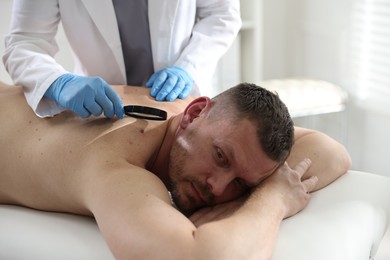 Photo of Doctor examining man's moles in hospital, closeup