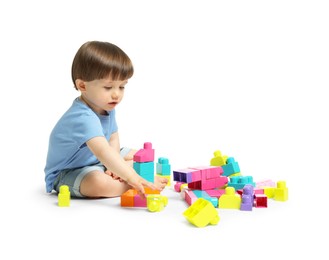 Photo of Cute little boy playing with building bricks on white background