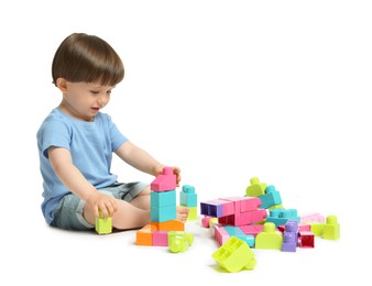 Photo of Cute little boy playing with building bricks on white background