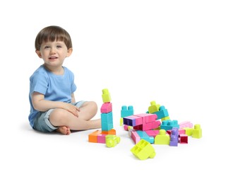 Photo of Cute little boy playing with building bricks on white background