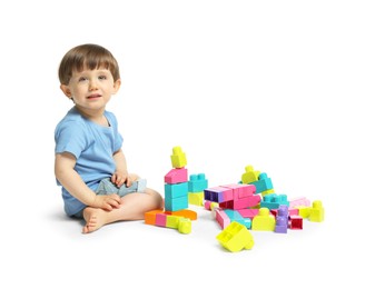 Photo of Cute little boy playing with building bricks on white background