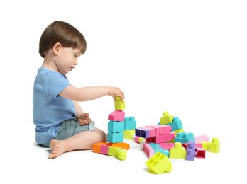 Photo of Cute little boy playing with building bricks on white background