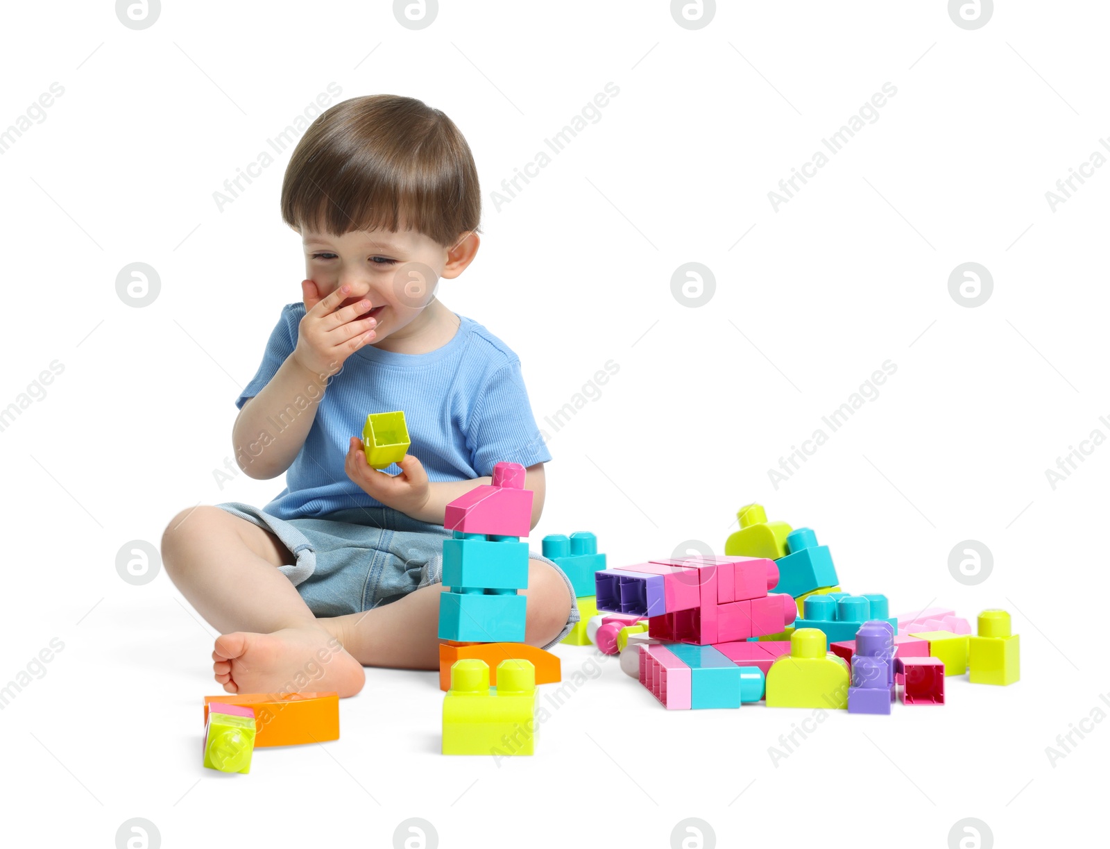 Cute little boy playing with building bricks on white background Photo of Cute little boy playing with building bricks on white background