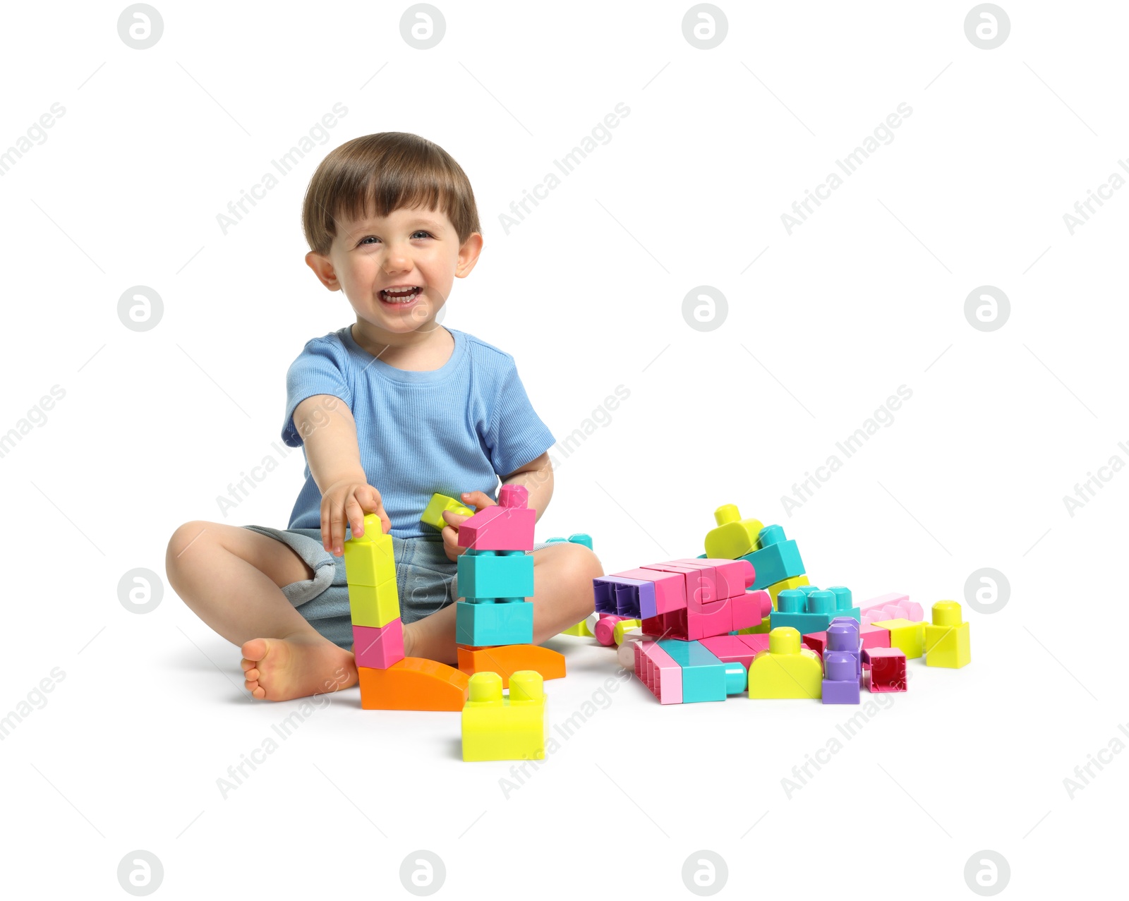 Cute little boy playing with building bricks on white background Photo of Cute little boy playing with building bricks on white background
