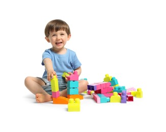 Photo of Cute little boy playing with building bricks on white background