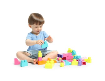 Photo of Cute little boy playing with building bricks on white background