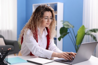 Photo of Woman working with laptop at desk in home office