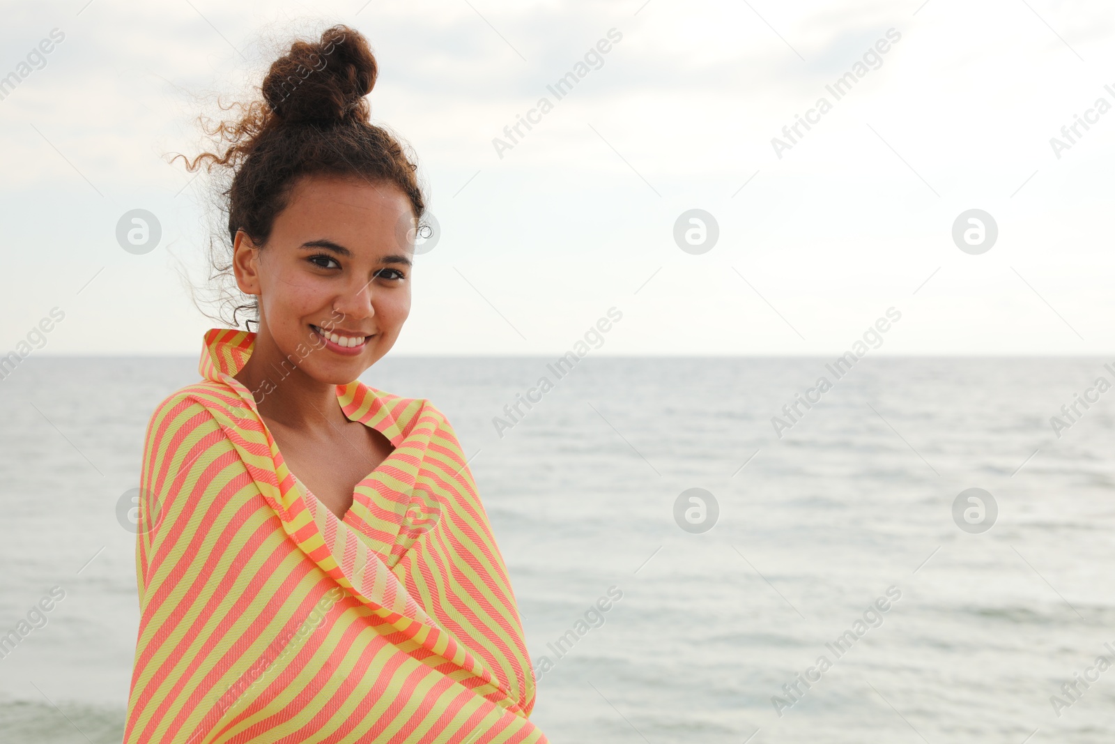 Beautiful African American woman with beach towel near sea Photo of Beautiful African American woman with beach towel near sea