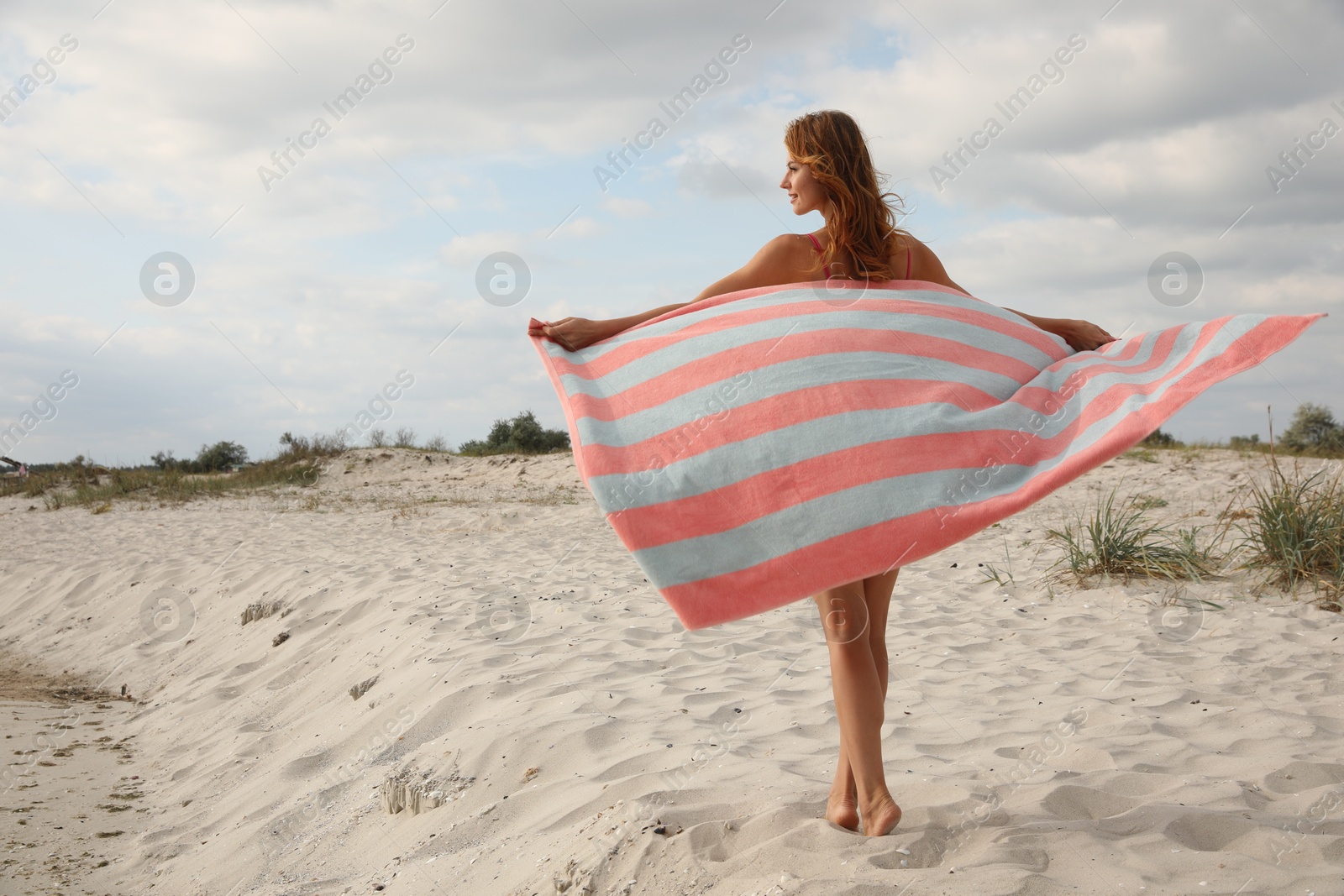 Beautiful woman with beach towel on sand Photo of Beautiful woman with beach towel on sand